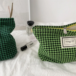 Detail view of houndstooth toiletry bags with silver zippers and Pleasant Time labels