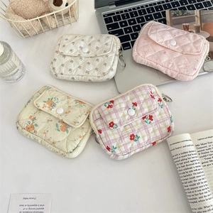 Close-up of quilted floral fabric card holders with flap covers and metal ring zippers