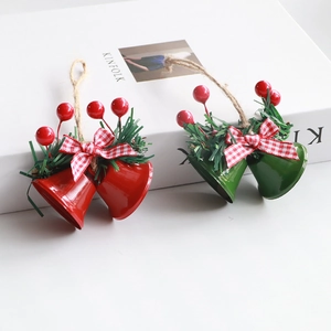 Christmas double horn bells with red-white plaid bow and pine needles decor on white surface