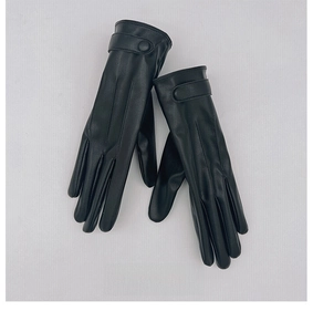 Dettaglio di guanti in pelle PU nera con cinturino decorativo e un elegante bottone rotondo
