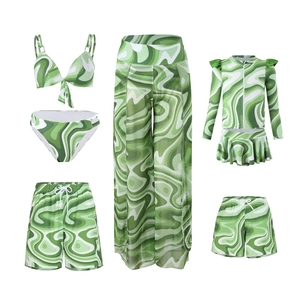 Detail view of matching family swimwear set with green and white wave geometric patterns