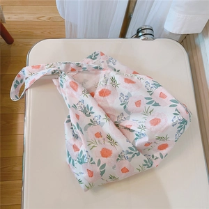 Detail view of cotton floral tote bag featuring pink peony prints on a cream background