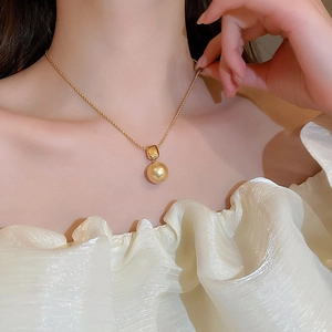 Gros plan d'un collier plaqué or 18 carats avec perle champagne et chaîne torsadée