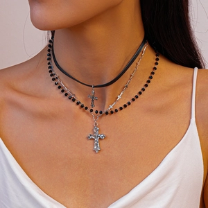 Close-up of gothic triple-layer necklace with cross pendants and black beads on neck