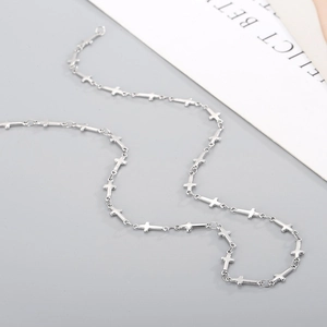Detailed close-up of a silver stainless steel chain featuring small linked crosses