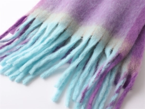 Detail view of purple-blue gradient scarf featuring long tassels and fuzzy wool texture