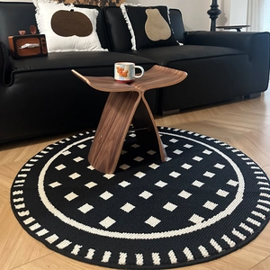 French cream style round geometric rug with black and white checkered pattern in living room