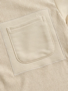 Macro shot of stitching detail on beige corduroy pocket and premium textured fabric