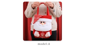 Detail of Christmas gift bag with 3D Santa Claus figure and red knitted handle