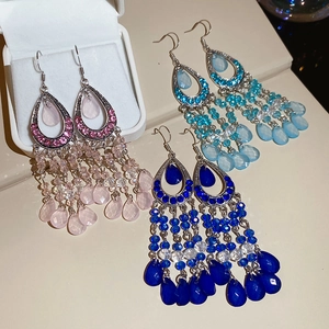 Detail of bohemian tassel earrings with rhinestones and pink, blue water drop beads