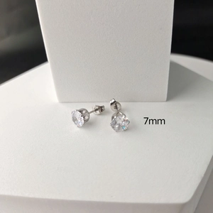 Detail view of 7mm six-prong cubic zirconia stud earring on white geometric stand