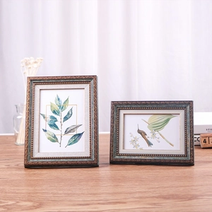 Bronze retro European photo frames with leaf art on a wooden table, horizontal and vertical