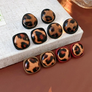 Vue détaillée de boucles d'oreilles léopard en similicuir aux formes rondes et carrées