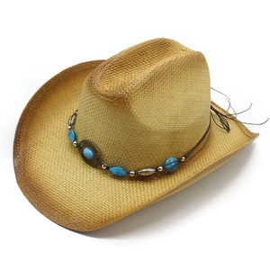 Handwoven straw Panama hat with turquoise beads and vintage metal decor on white background