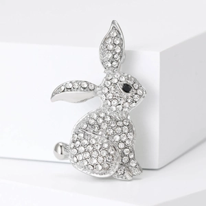 Sparkling silver rabbit brooch with clear rhinestones and black eye on white background