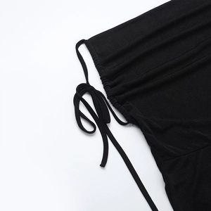 Close-up of black knitted fabric detailing the drawstring ruched texture on the jumpsuit