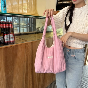 Detail of pink pleated tote bag with fabric label and unique vertical crinkle texture