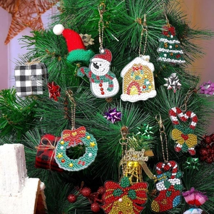 Close-up of Christmas DIY diamond painting keychains hanging on a festive pine tree