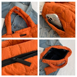 Detailed view of orange quilted tote bag featuring zippers and a matching small pouch