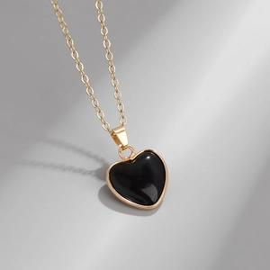 Detailed close-up of a heart-shaped black stone pendant with elegant gold plating on chain