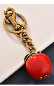 Detail of red apple keychain with vintage bronze lobster clasp and metallic finish