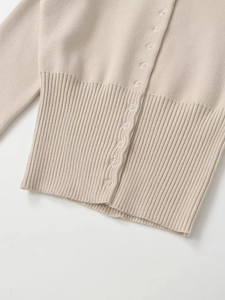 Detailansicht beige Strickjacke mit Metalldruckknöpfen und gerippten Bündchen