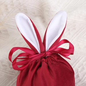 Detailed view of red velvet Easter bunny ear gift bag with ribbon bow and soft texture