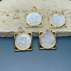 Square gold angel pendant with white mother of pearl inlay on coral and blue background
