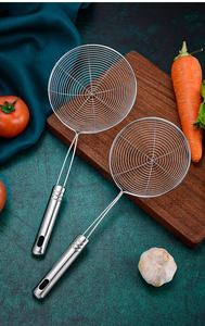 Dual-size stainless steel wire strainers with metal handles on a wooden board