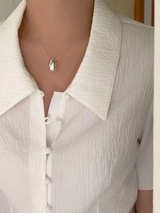 Minimalist 925 sterling silver double-sided teardrop pendant necklace on a female model
