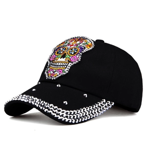Detailed macro view of sugar skull embroidery and rhinestones on black baseball cap