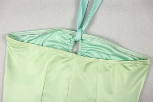 Detail of mint green satin halter neck dress featuring pleated texture and vertical stitching
