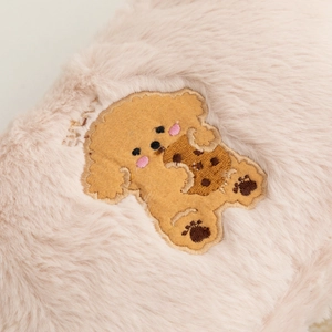 Detail shot of cute puppy embroidery on a soft pink plush cosmetic storage bag