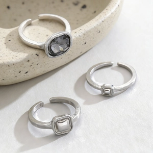 Three-piece silver metal ring set with grey oval gemstone and geometric square designs