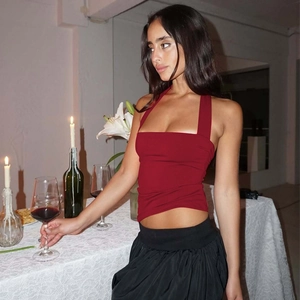 Détail d'un haut licou rouge ajusté avec texture douce dans une scène de dîner romantique