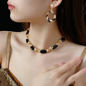 Vintage gold and black enamel jewelry set with twisted geometric necklace and earrings