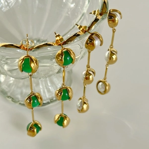 Close-up of vintage 18k gold plated drop earrings with green chalcedony and white pearls