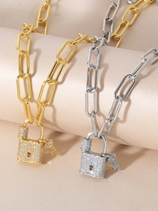 Detail of gold and silver padlock necklaces with micro-pave zircons and small key charms