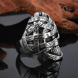Macro detail of mummy skull ring with intricate bandage texture in matte vintage steel