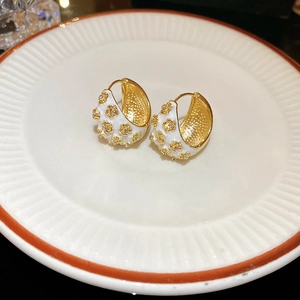 Elegant gold C-shaped earrings with white enamel coating and crystal flower accents