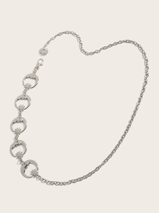 Détail d'une chaîne de taille en métal argenté avec pendentifs soleil et lune