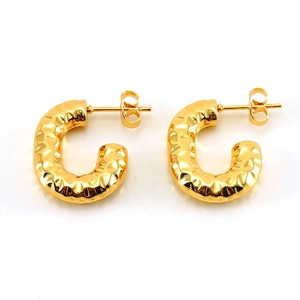 Detailansicht goldener C-Ohrringe mit einer gehämmerten Metallstruktur im Vintage-Stil