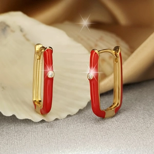 Macro detail of red enamel rectangular earrings with cubic zirconia on white shell