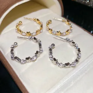Sparkling star-shaped C-shaped earrings with white zircons in gold and silver finish
