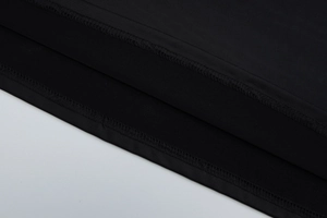 Close-up detail of smooth black fabric with precise stitching and high-quality edge finish