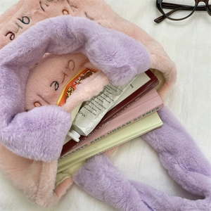 Détail du sac cabas en peluche brodé montrant sa grande capacité pour livres et soins