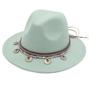 Dettaglio cappello fedora verde menta con fascia in pelle etnica e ciondoli a moneta