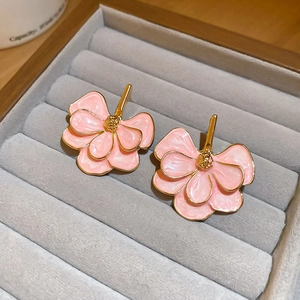 Close-up of pink enamel ginkgo flower earrings in a velvet jewelry display box