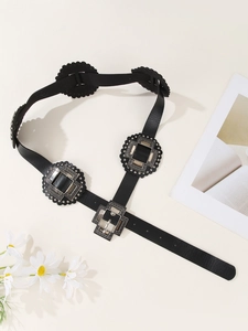 Detail of vintage black PU leather belt with ornate silver floral carved metal buckles