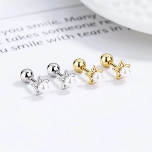 Detailed view of silver and gold star earrings with pearls and threaded ball backs